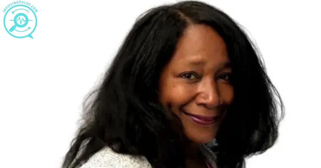 Kelly South smiling, close-up portrait with long black hair.