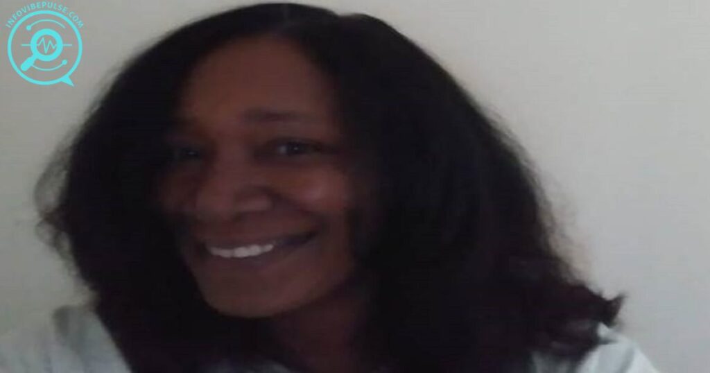Kelly South smiling in a low-light photo, wearing a white shirt.