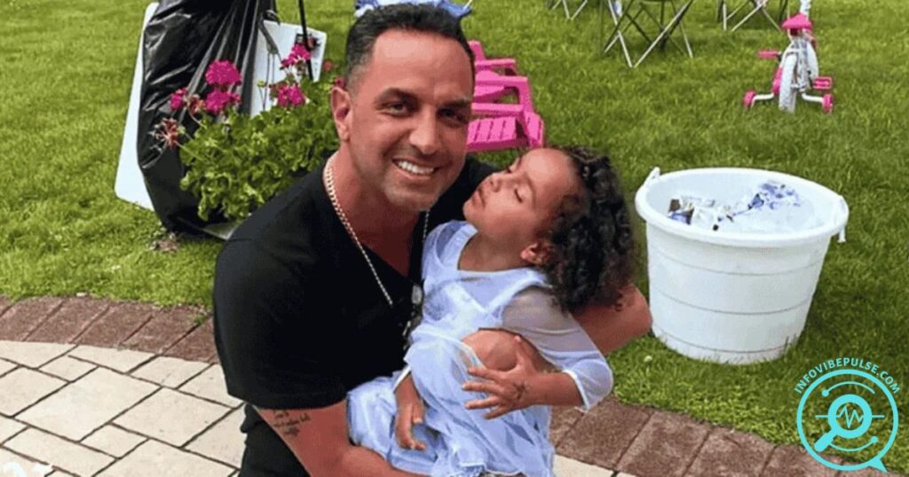 Dino Guilmette smiling and holding his young daughter at an outdoor event.